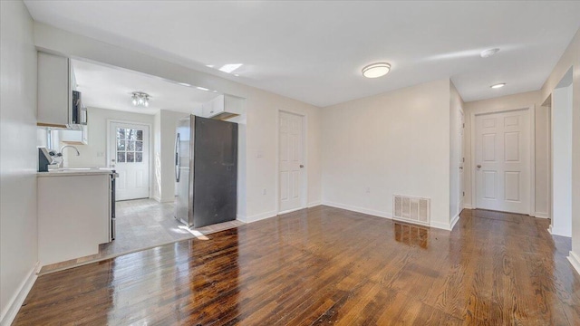 interior space featuring visible vents, baseboards, and wood finished floors