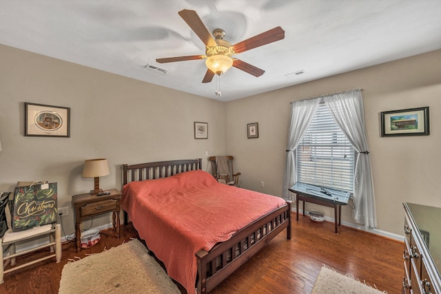 bedroom featuring visible vents, ceiling fan, baseboards, and wood finished floors