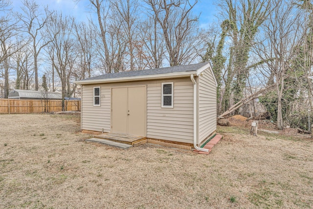 view of outbuilding with fence and an outbuilding