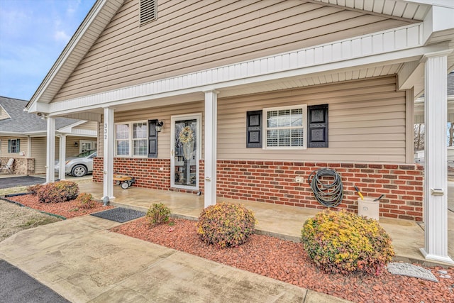 exterior space with covered porch and brick siding