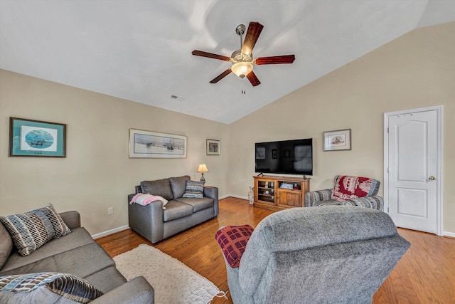 living area with visible vents, a ceiling fan, vaulted ceiling, baseboards, and light wood finished floors