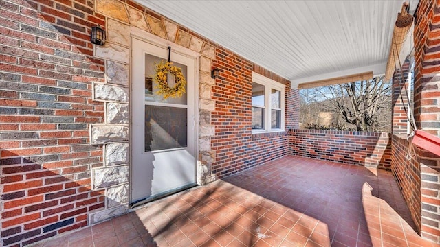 exterior space with a porch and brick siding