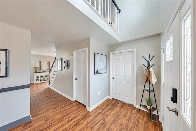 entryway featuring stairway, wood finished floors, and baseboards