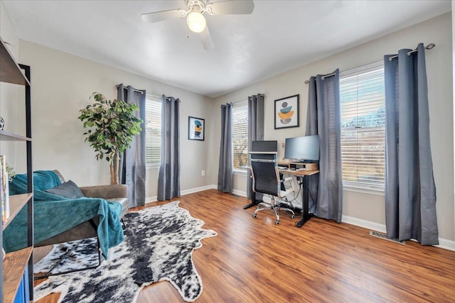 office space with a ceiling fan, baseboards, and wood finished floors