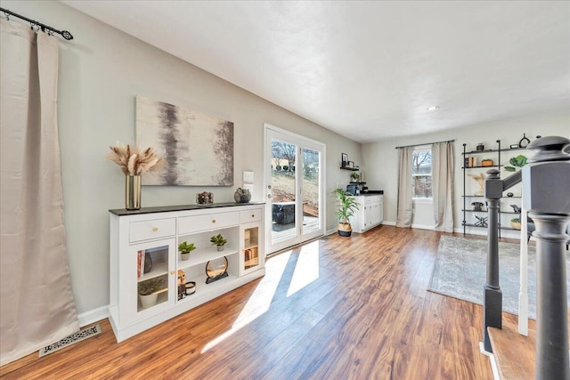 exercise room with baseboards, visible vents, and wood finished floors