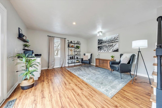 living area with baseboards, visible vents, and wood finished floors