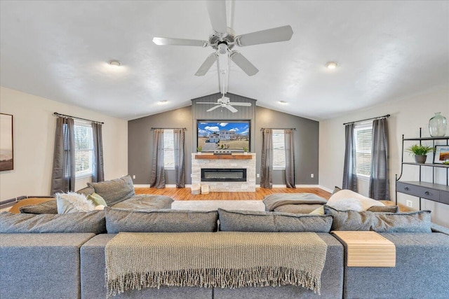 living room featuring lofted ceiling, a fireplace, plenty of natural light, and wood finished floors