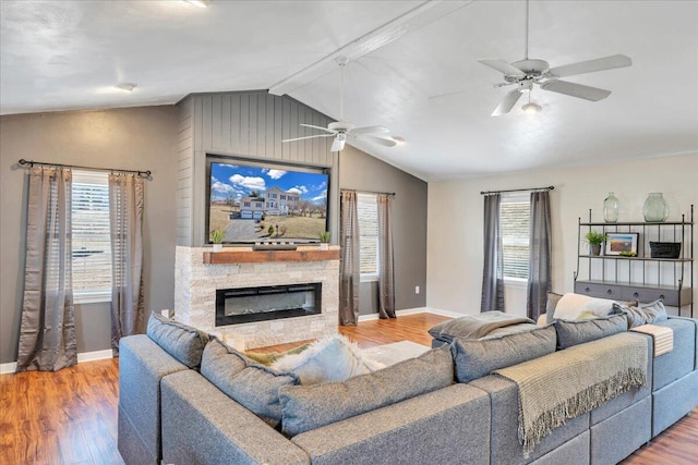 living room with a healthy amount of sunlight, lofted ceiling with beams, and wood finished floors