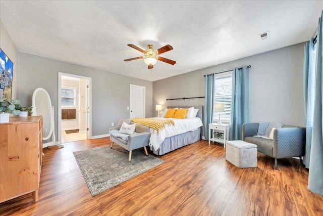 bedroom featuring ceiling fan, wood finished floors, visible vents, and baseboards