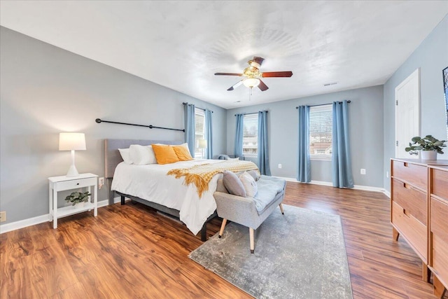 bedroom with ceiling fan, baseboards, and wood finished floors