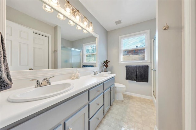 full bathroom with double vanity, a sink, visible vents, and a shower stall