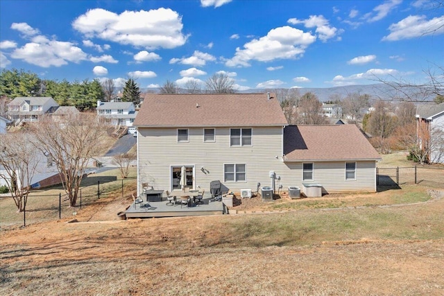 back of property featuring central AC unit, fence, a lawn, and a wooden deck