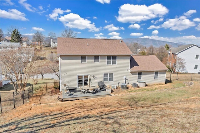 back of house featuring cooling unit, a fenced backyard, a lawn, and a deck with mountain view