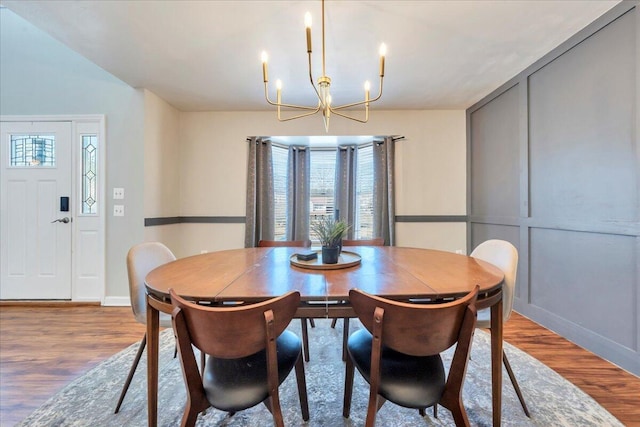 dining space featuring wood finished floors and a notable chandelier