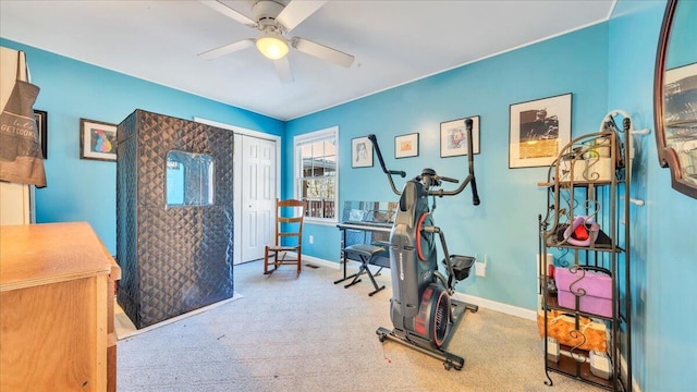 exercise area featuring a ceiling fan, carpet flooring, and baseboards