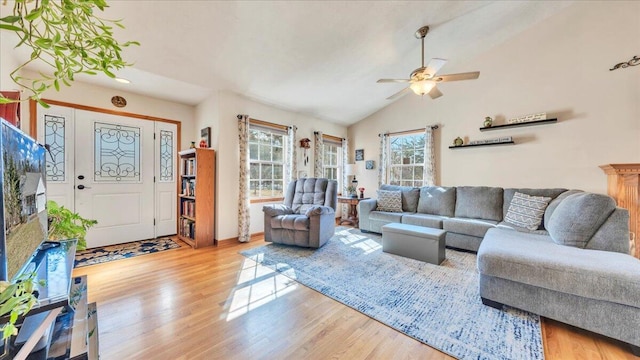 living room with a ceiling fan, lofted ceiling, and wood finished floors