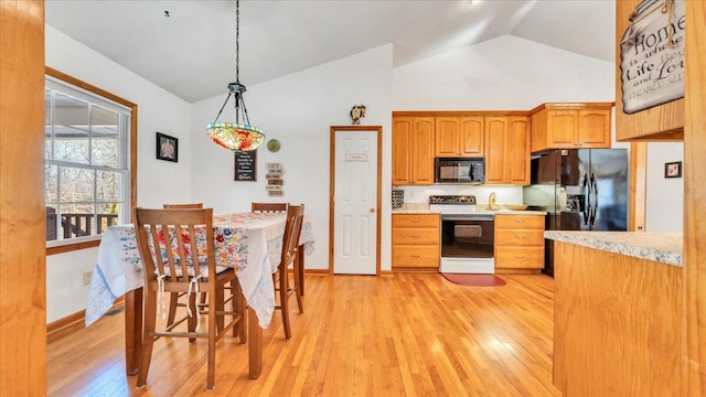 kitchen with light countertops, light wood-style flooring, and black appliances