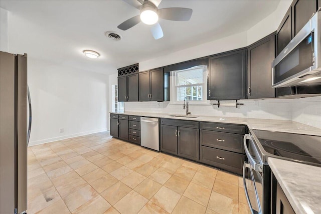 kitchen with visible vents, a sink, stainless steel appliances, light countertops, and decorative backsplash