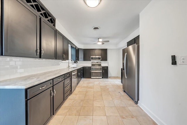 kitchen with visible vents, ceiling fan, a sink, appliances with stainless steel finishes, and backsplash