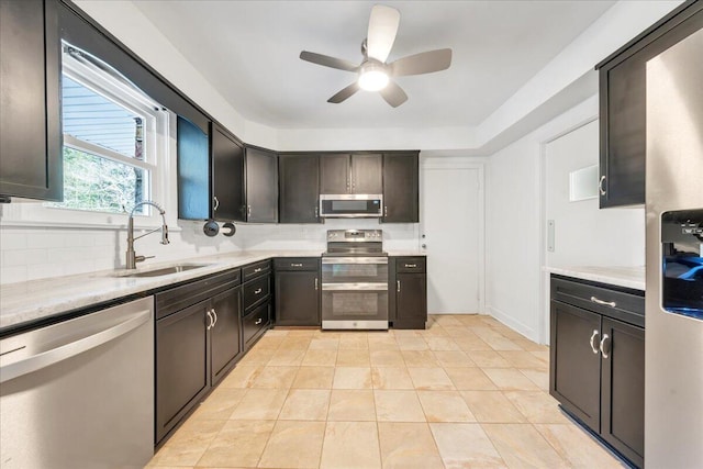 kitchen featuring backsplash, stainless steel appliances, light countertops, and a sink