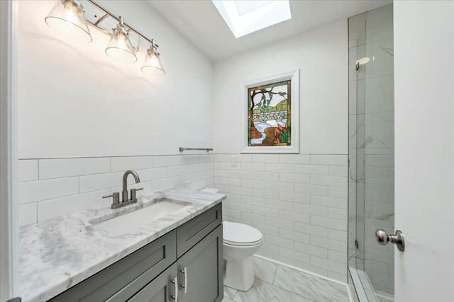 full bath featuring toilet, tile walls, a skylight, tiled shower, and vanity