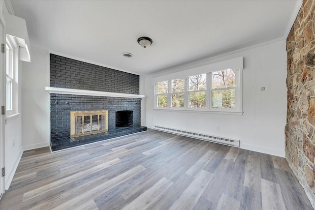 unfurnished living room featuring visible vents, ornamental molding, a baseboard heating unit, wood finished floors, and a brick fireplace