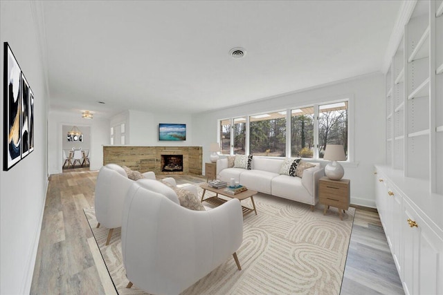 living room with a fireplace, visible vents, light wood finished floors, and baseboards