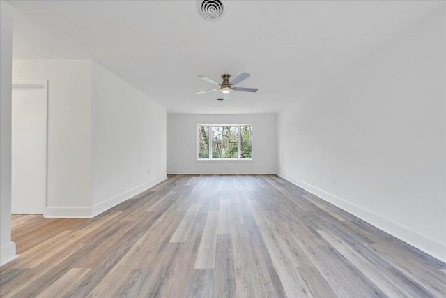 empty room with visible vents, baseboards, wood finished floors, and a ceiling fan