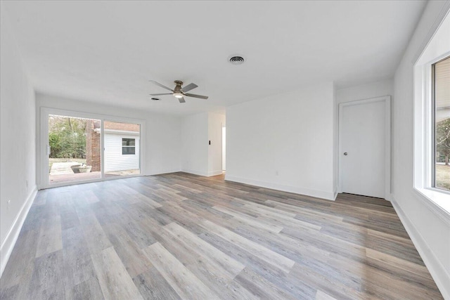 unfurnished living room featuring plenty of natural light, baseboards, and light wood-style floors