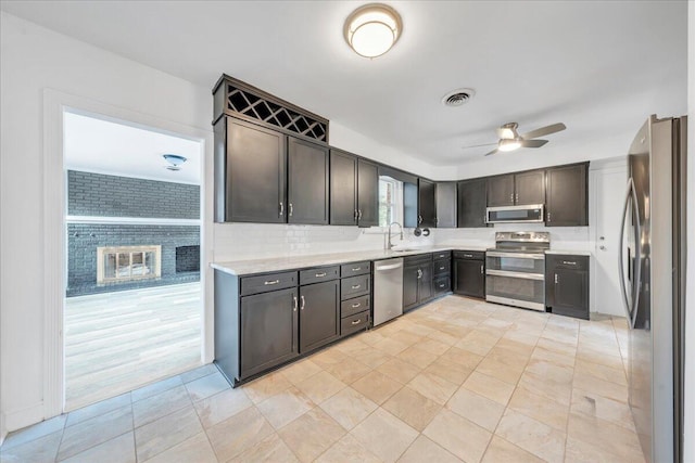 kitchen featuring visible vents, a sink, dark brown cabinetry, appliances with stainless steel finishes, and ceiling fan