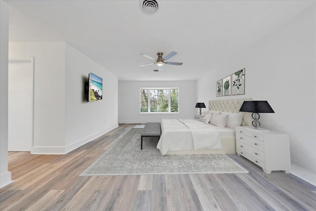 bedroom featuring visible vents, light wood-style flooring, baseboards, and ceiling fan