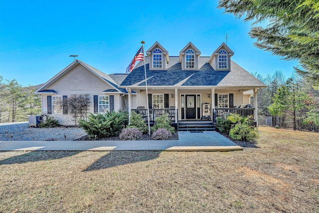 view of front of home featuring covered porch, a front lawn, and a shingled roof