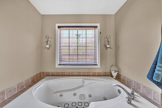 full bath featuring a tub with jets and a textured ceiling