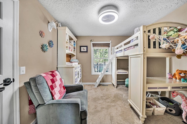 bedroom with a textured ceiling, carpet floors, and baseboards