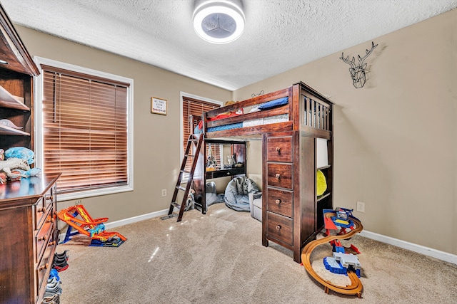 carpeted bedroom with a textured ceiling and baseboards