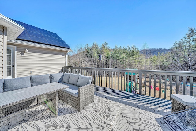 deck with an outdoor living space and a wooded view