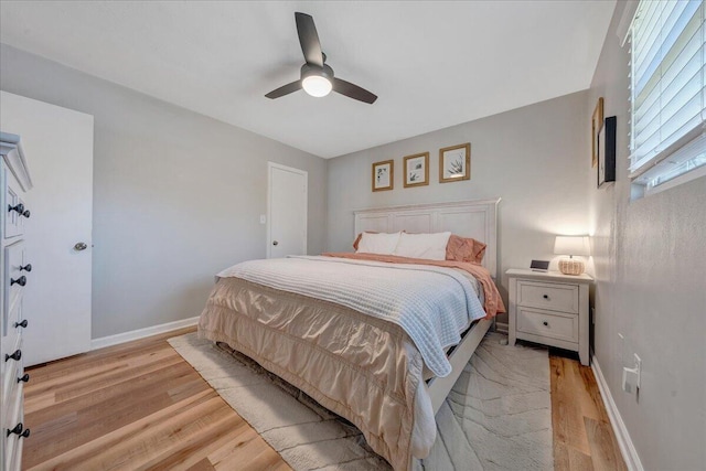 bedroom featuring baseboards, light wood-style floors, and a ceiling fan