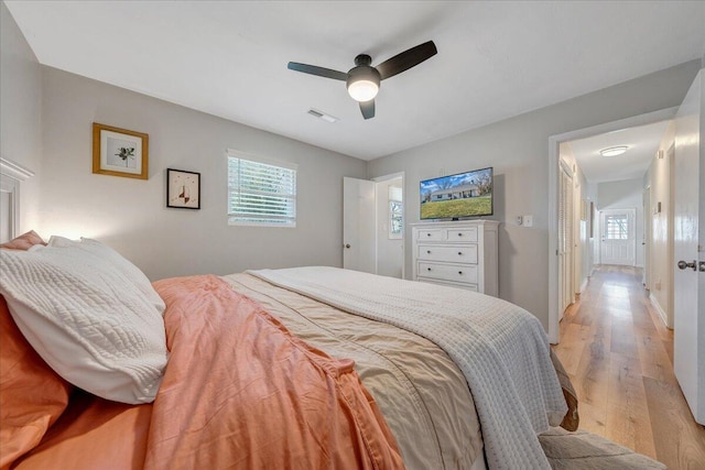 bedroom with visible vents, baseboards, light wood-style floors, and ceiling fan