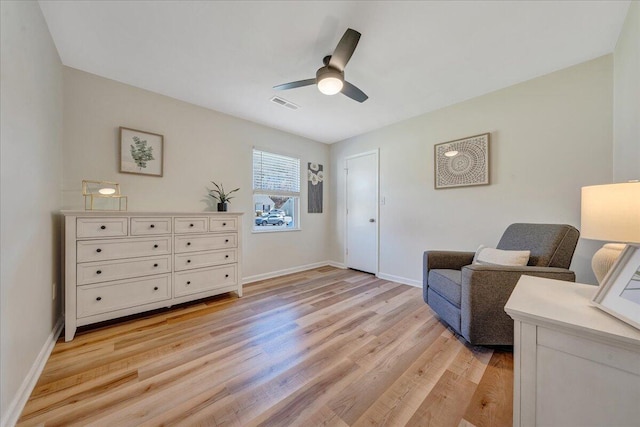 sitting room featuring light wood-style flooring, baseboards, visible vents, and ceiling fan