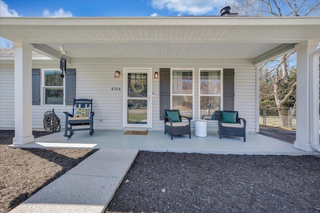 view of patio / terrace featuring a porch and fence