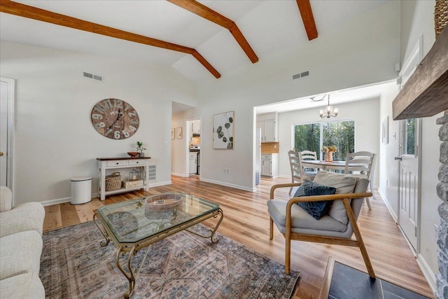 living room with beam ceiling, visible vents, a chandelier, and light wood-type flooring