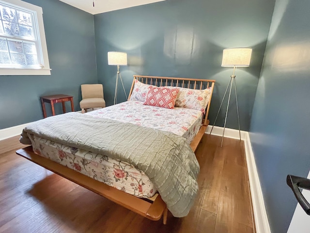 bedroom with baseboards and wood finished floors