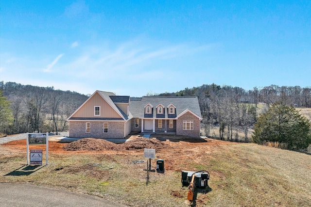 view of front of property featuring a view of trees and solar panels