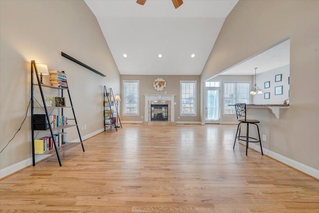 living area with light wood-style floors, a fireplace, and plenty of natural light