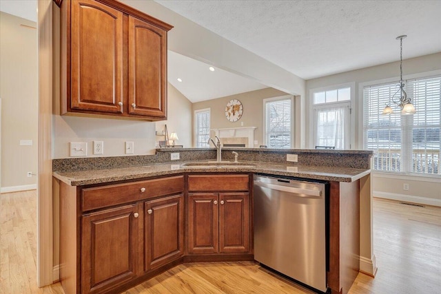 kitchen with stainless steel dishwasher, light wood-style flooring, a sink, and a wealth of natural light