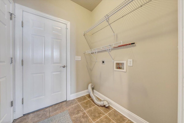 clothes washing area featuring hookup for a washing machine, hookup for an electric dryer, laundry area, baseboards, and tile patterned floors