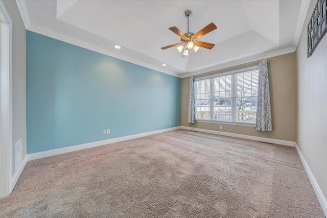 unfurnished room featuring carpet floors, baseboards, a raised ceiling, and crown molding