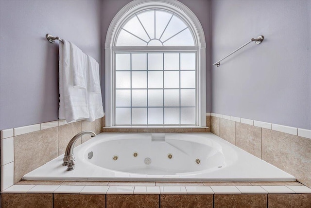 bathroom with a tub with jets and a wealth of natural light