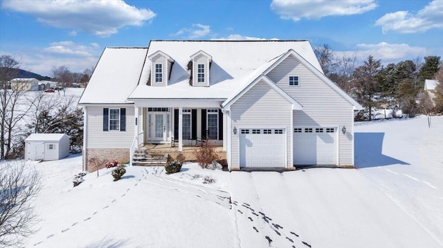 new england style home with a garage, a shed, covered porch, and an outbuilding