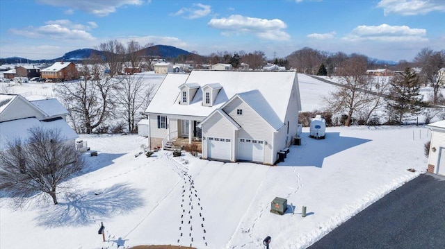 view of front of house with a garage, central AC unit, and a mountain view